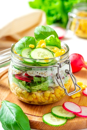 Ein Glas voller Vitamine: ein gemischter Salat mit Gurken, Spinat, Radieschen, Dip und Mais im Bügelglas. Toll zum Vorbereiten und mit nehmen